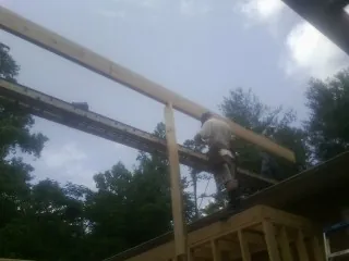 Carpenter setting a ridge beam over a new addition frame — Ice Dam Removal by Roofing Brothers in York Beach
