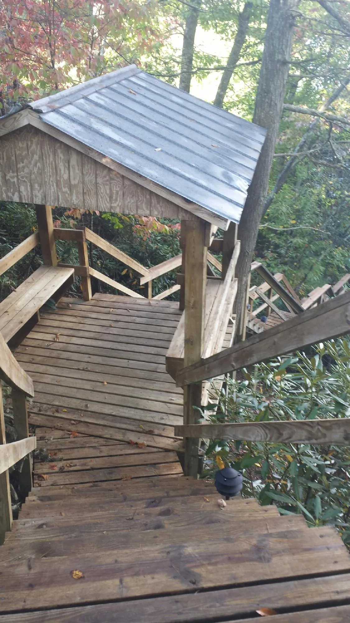 Metal roofed shelter over wooden steps on a wooded walkway — Skylight Repair & Installation work by our crew in York Beach